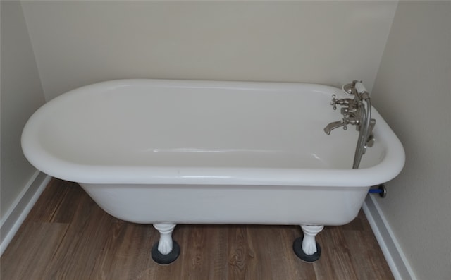 bathroom with hardwood / wood-style floors and a tub