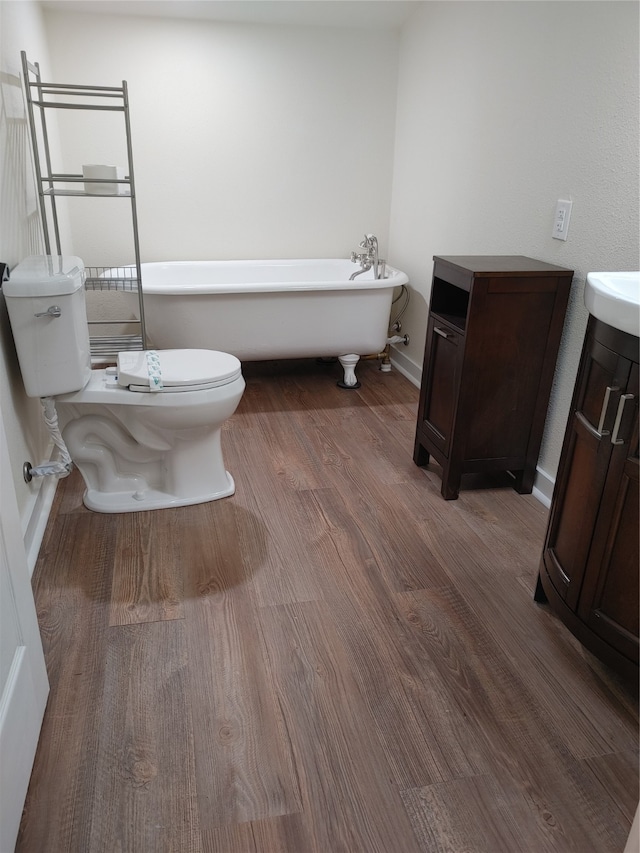 bathroom featuring a washtub, toilet, vanity, and hardwood / wood-style floors