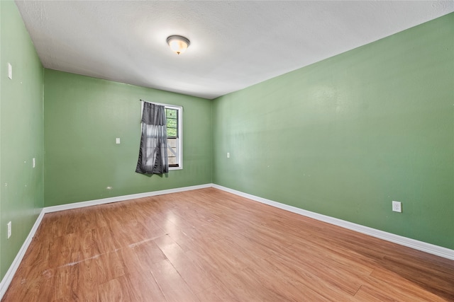 empty room featuring a textured ceiling and hardwood / wood-style floors