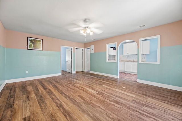 empty room with wood-type flooring and ceiling fan