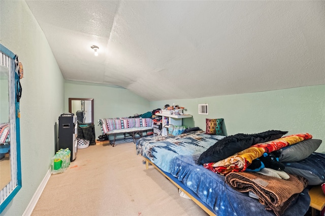 bedroom with vaulted ceiling, carpet flooring, and a textured ceiling