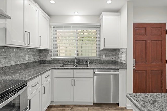 kitchen with dark hardwood / wood-style floors, ventilation hood, sink, white cabinetry, and appliances with stainless steel finishes