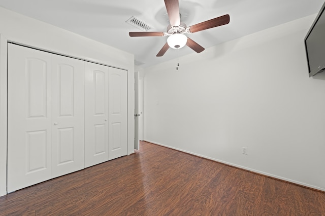 unfurnished bedroom with dark hardwood / wood-style flooring, ceiling fan, and a closet