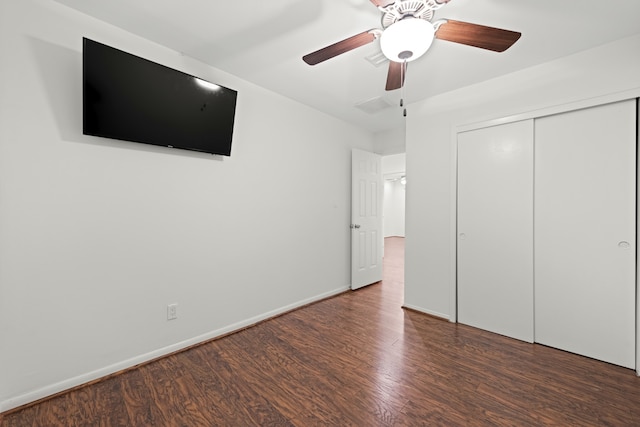 unfurnished bedroom featuring dark hardwood / wood-style floors, ceiling fan, and a closet