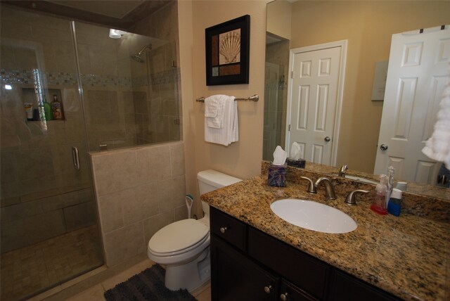 bathroom with a shower with door, vanity with extensive cabinet space, and toilet