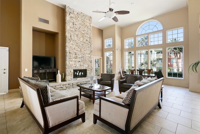 living room with a wealth of natural light, ceiling fan, and a fireplace