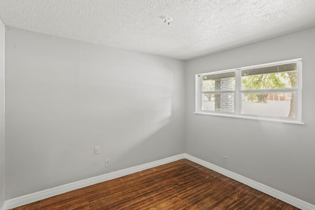 unfurnished room with dark hardwood / wood-style flooring and a textured ceiling