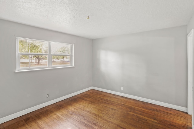 unfurnished room with dark hardwood / wood-style floors and a textured ceiling