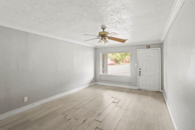 empty room featuring a textured ceiling, ceiling fan, light wood-type flooring, and ornamental molding