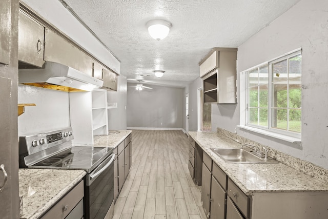 kitchen with stainless steel range with electric stovetop, sink, light hardwood / wood-style floors, ceiling fan, and a textured ceiling