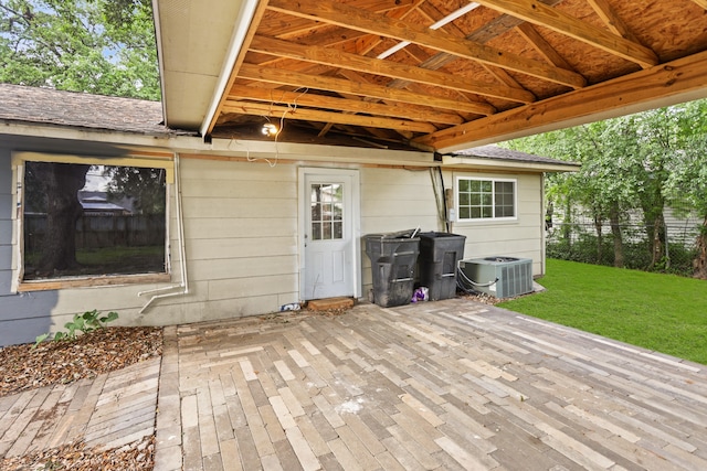 wooden deck featuring a patio, central air condition unit, and a lawn