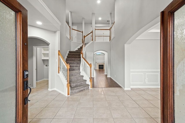 foyer with a towering ceiling and light wood-type flooring