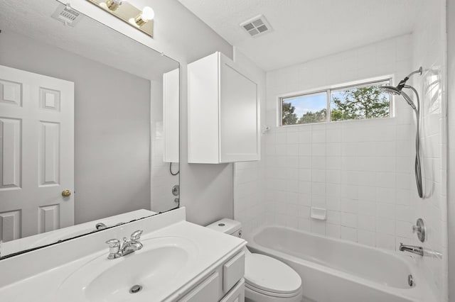 full bathroom featuring vanity, tiled shower / bath combo, toilet, and a textured ceiling