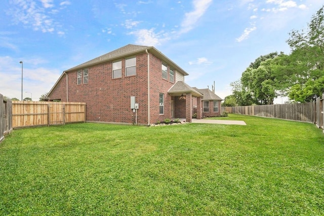 rear view of house featuring a yard and a patio area