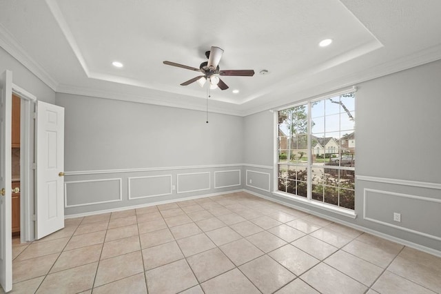 unfurnished room featuring ornamental molding, ceiling fan, light tile floors, and a tray ceiling