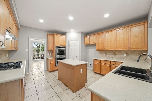 kitchen featuring a center island, backsplash, stainless steel appliances, light tile floors, and sink