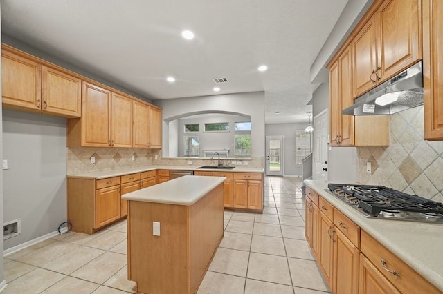 kitchen with backsplash, sink, a kitchen island, and light tile flooring