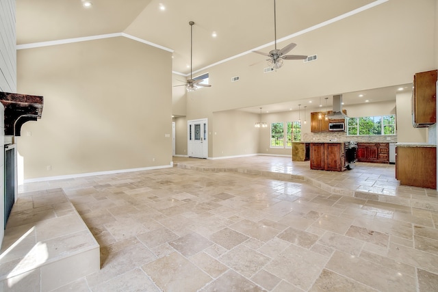 unfurnished living room with ornamental molding, ceiling fan, light tile flooring, and a high ceiling