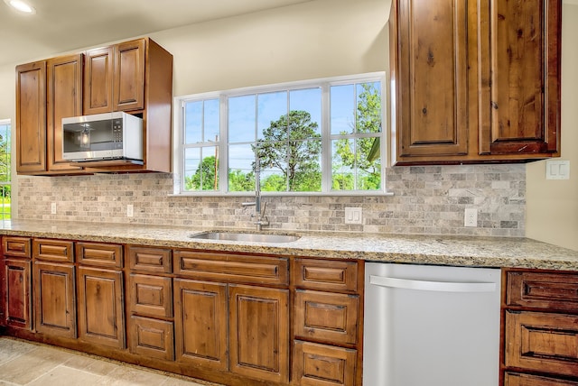 kitchen featuring backsplash, appliances with stainless steel finishes, and light stone counters