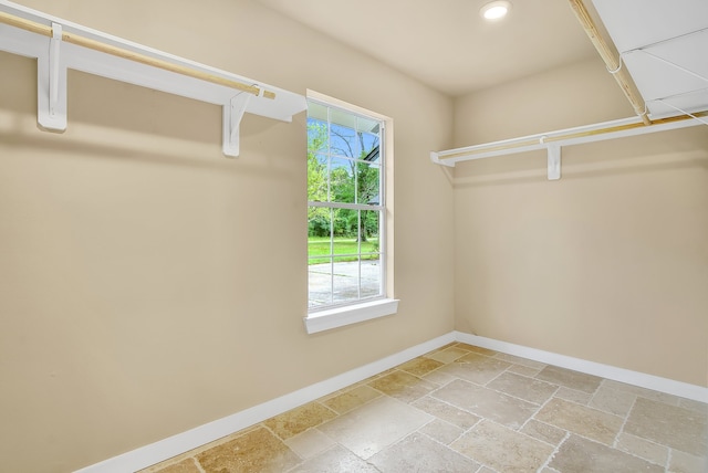 walk in closet with light tile floors