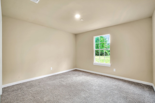 spare room featuring dark carpet