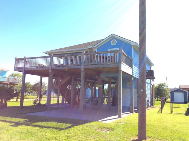 rear view of property featuring a yard, a patio area, and a deck