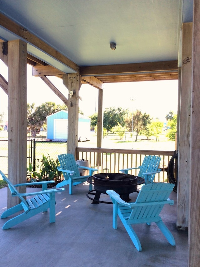 view of patio with a shed and an outdoor fire pit