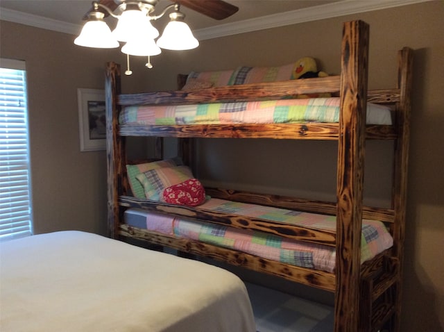 bedroom featuring crown molding and ceiling fan with notable chandelier