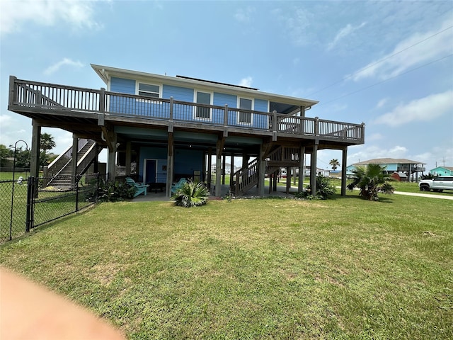 rear view of house with a wooden deck and a lawn