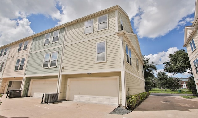 view of property exterior featuring central AC unit and a garage