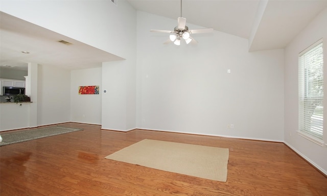 empty room with hardwood / wood-style floors, high vaulted ceiling, and ceiling fan