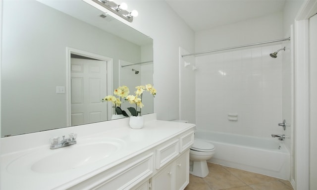 full bathroom featuring tile patterned flooring, vanity, tiled shower / bath, and toilet