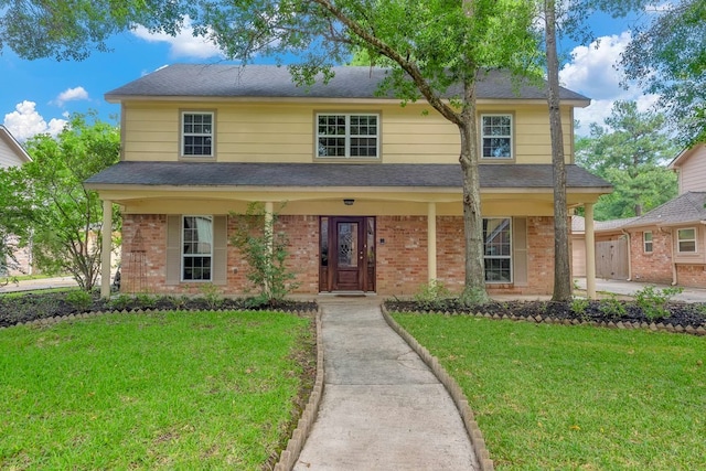 view of front of house with covered porch and a front yard