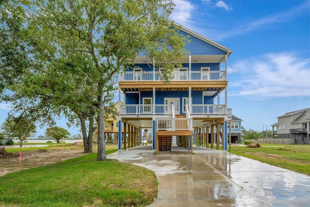 back of property with a yard, covered porch, and a carport