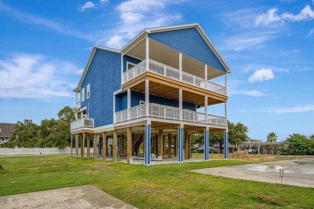 rear view of house with a yard, a carport, and a balcony