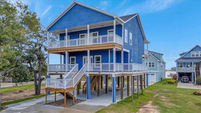 back of house with a balcony, a yard, a garage, a carport, and a porch