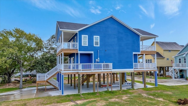 back of property with a balcony, a lawn, and a carport