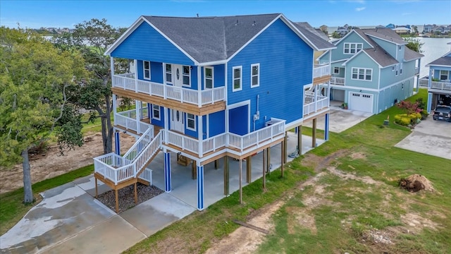 back of house featuring a balcony, a yard, a porch, and a garage