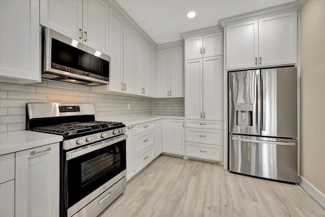 kitchen featuring light stone counters, tasteful backsplash, white cabinets, stainless steel appliances, and light wood-type flooring