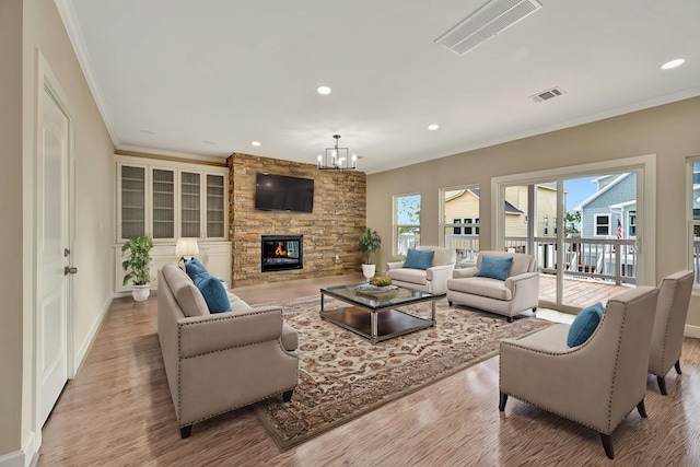 living room featuring a fireplace, crown molding, and light hardwood / wood-style floors