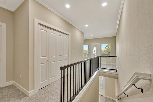 hallway featuring ornamental molding and light colored carpet