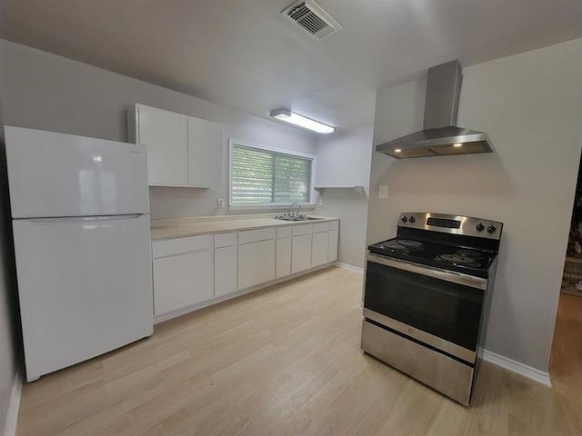 kitchen featuring stainless steel electric stove, sink, wall chimney exhaust hood, white fridge, and white cabinetry