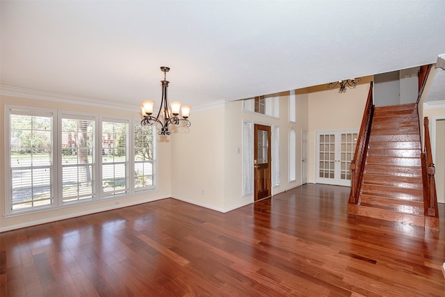 spare room featuring ornamental molding, dark hardwood / wood-style flooring, and a notable chandelier