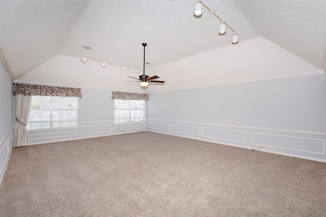 spare room with carpet, a textured ceiling, ceiling fan, track lighting, and lofted ceiling