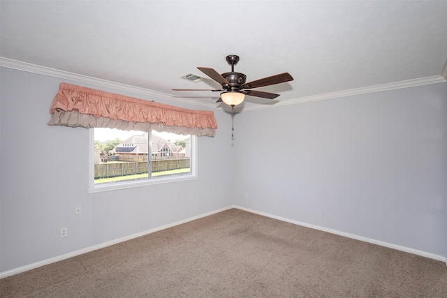 empty room featuring crown molding, carpet, and ceiling fan