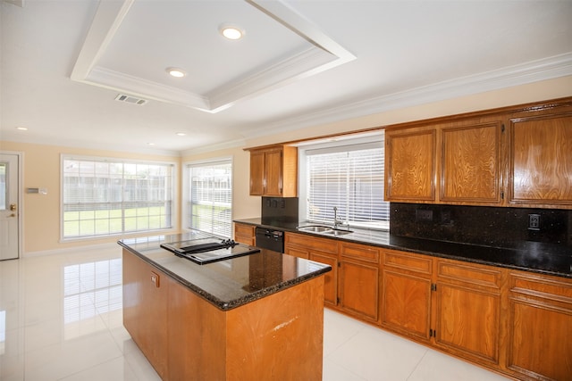 kitchen featuring a kitchen island, dark stone counters, a raised ceiling, and light tile flooring