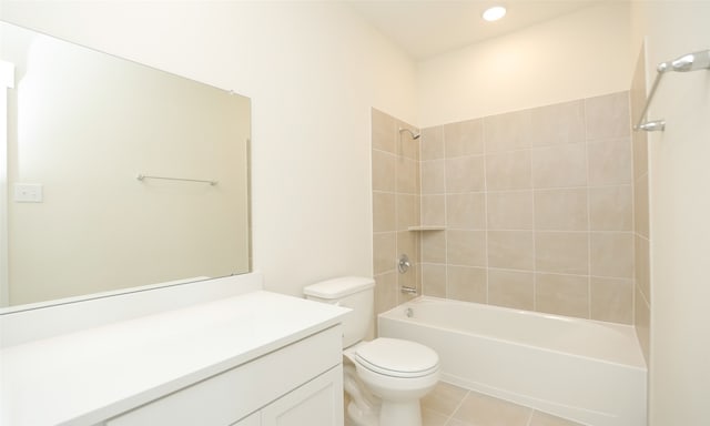 full bathroom featuring vanity, tile patterned flooring, toilet, and tiled shower / bath combo