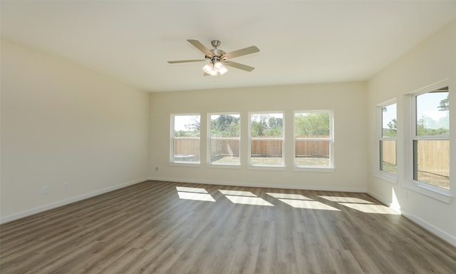 unfurnished room featuring ceiling fan and dark wood-type flooring