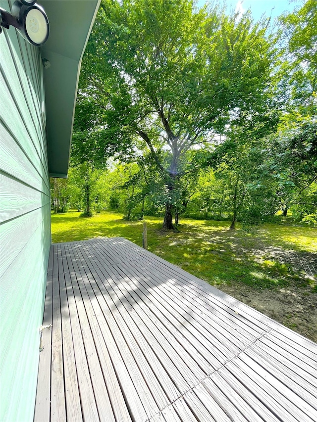 wooden deck featuring a lawn