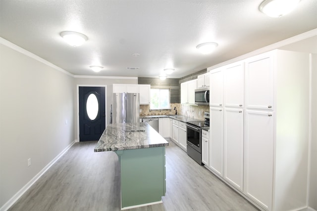 kitchen featuring appliances with stainless steel finishes, a center island, light wood-type flooring, and white cabinetry